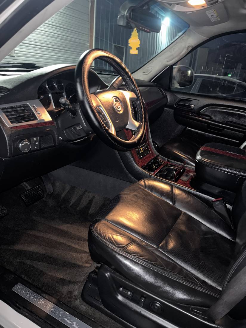 Detailed black leather car interior with steering wheel and dashboard